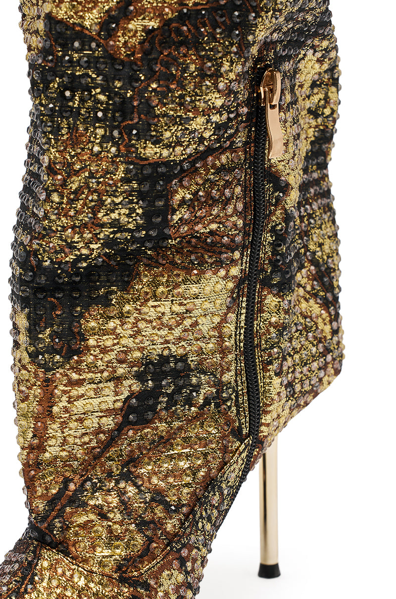 A close-up of the AZALEA WANG YARDLEY MULTI GOLD RHINESTONE COVERED OPEN TOE BOOT with black and bronze glittery fabric, knee-high stiletto heel, side zipper, and metallic accents.