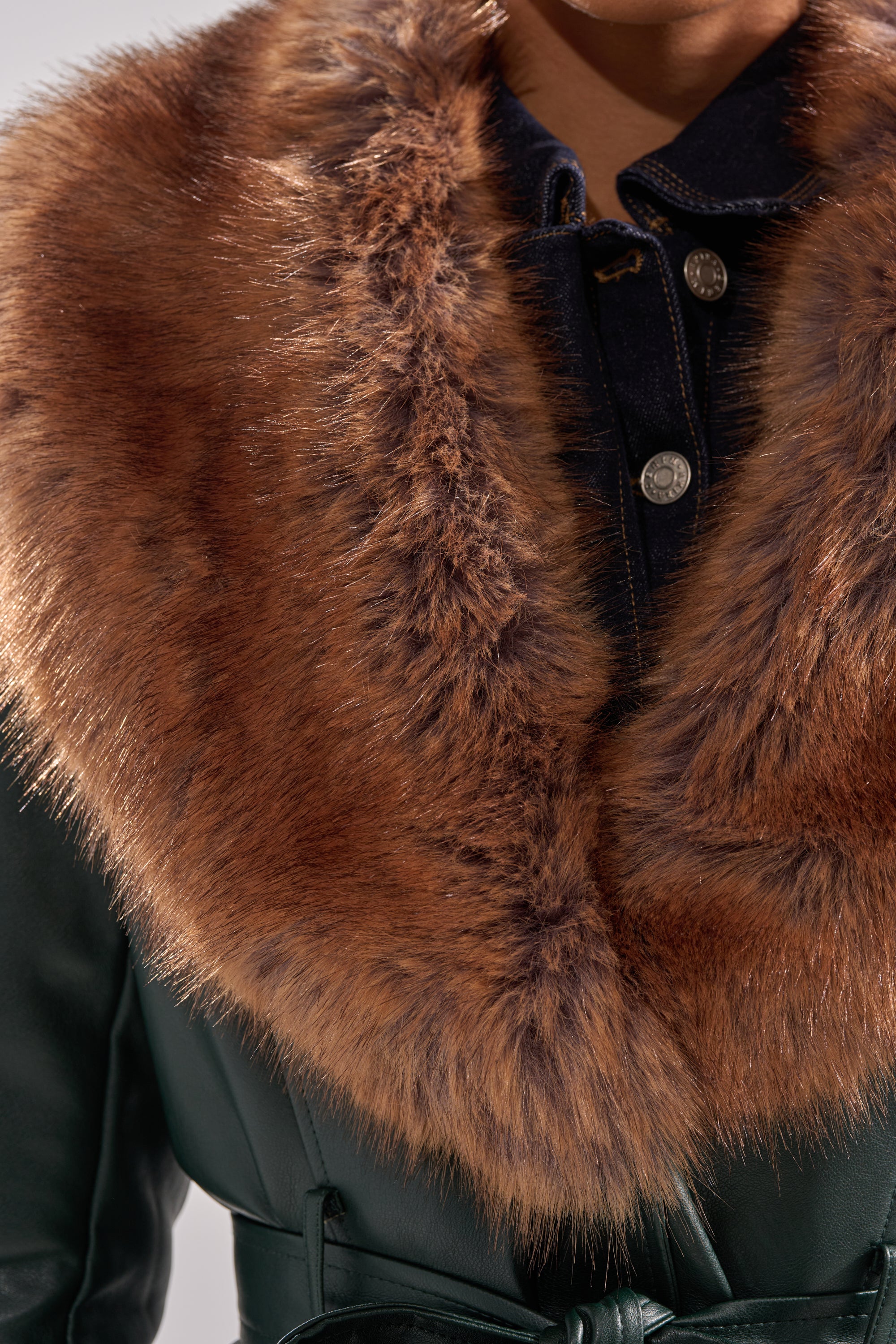 Close-up of a person wearing the GREENVIEW FUR TRIM TRENCH, featuring a wide, luxurious brown faux fur collar and soft, voluminous fur trim over a dark denim shirt with silver buttons.