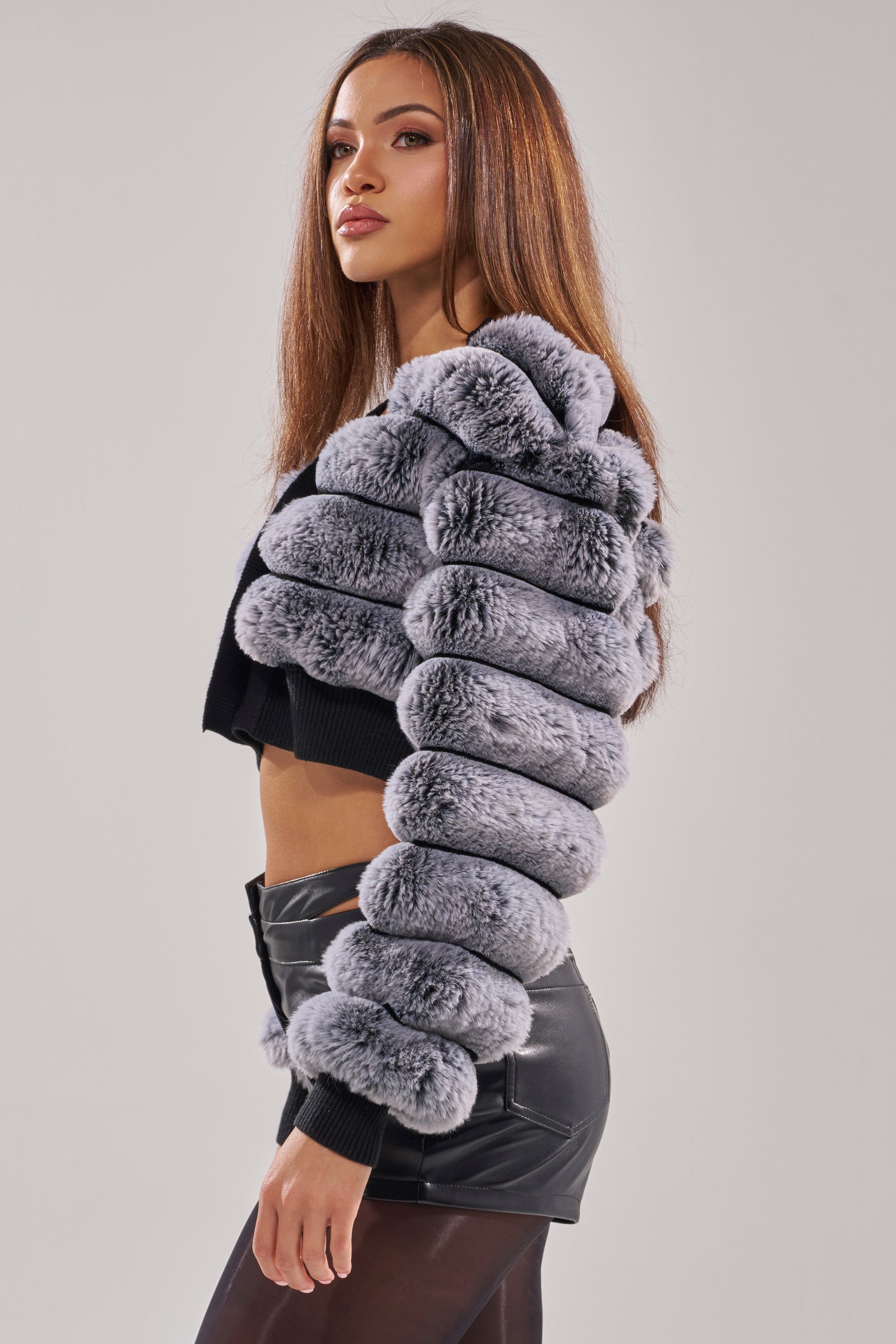 A woman in a chic WILD HEART FAUX FUR CARDIGAN.