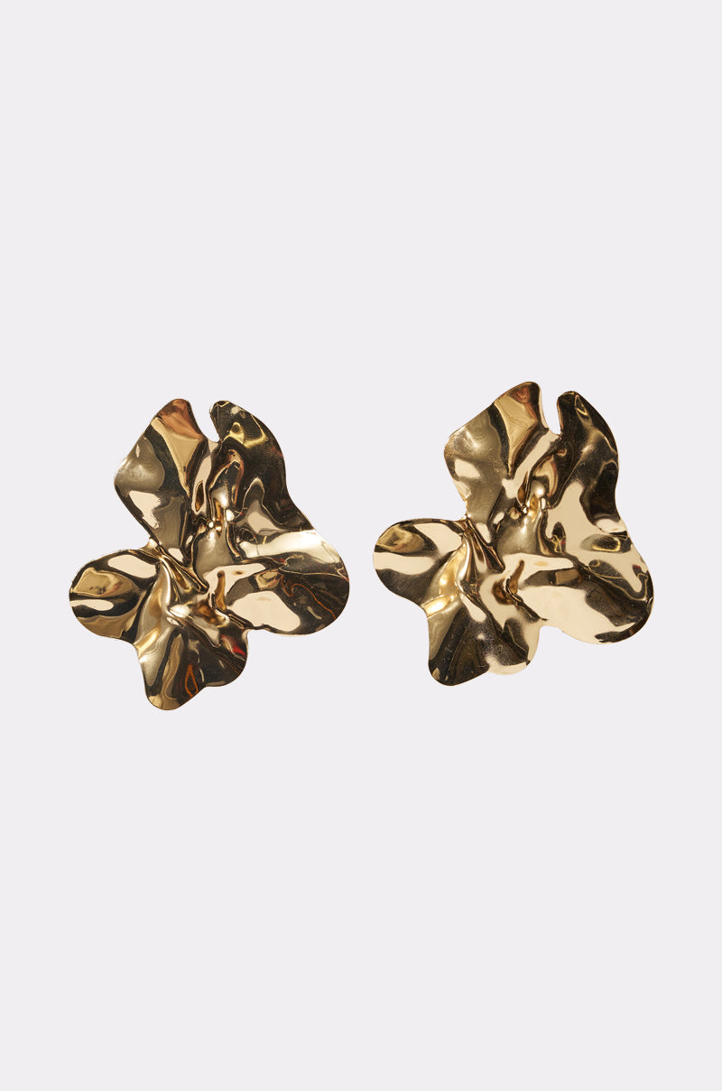 The ORGANIC VIBES EARRING is a pair of shiny gold statement earrings in an abstract flower shape with a crumpled, sculptural texture, shown against a plain light background. 2