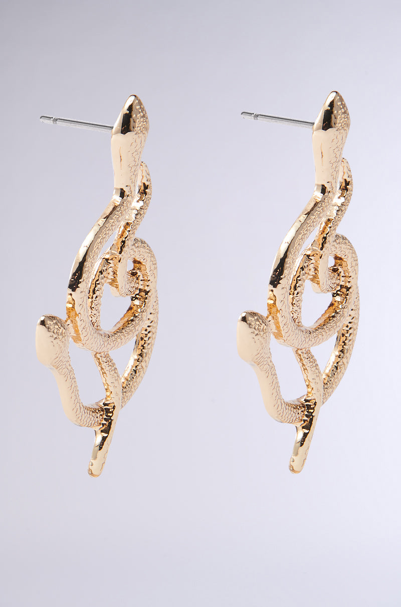 Close-up of WATCH YA STEP EARRING from AKIRA Label, showcasing its faux gold snake design with a textured surface and post back, set on a neutral background.