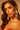 A woman with wavy brown hair confidently gazes into the camera, wearing the CHANDELIER DROP EARRING and a strapless red top against a warm, neutral background.