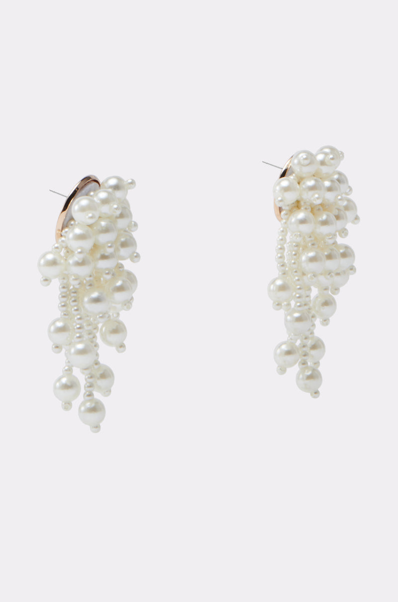 Elevate your bridal style with the REGAL PEARL DROP EARRING—dangle earrings featuring cascading clusters of white faux pearls, shown on a plain light gray background. 2