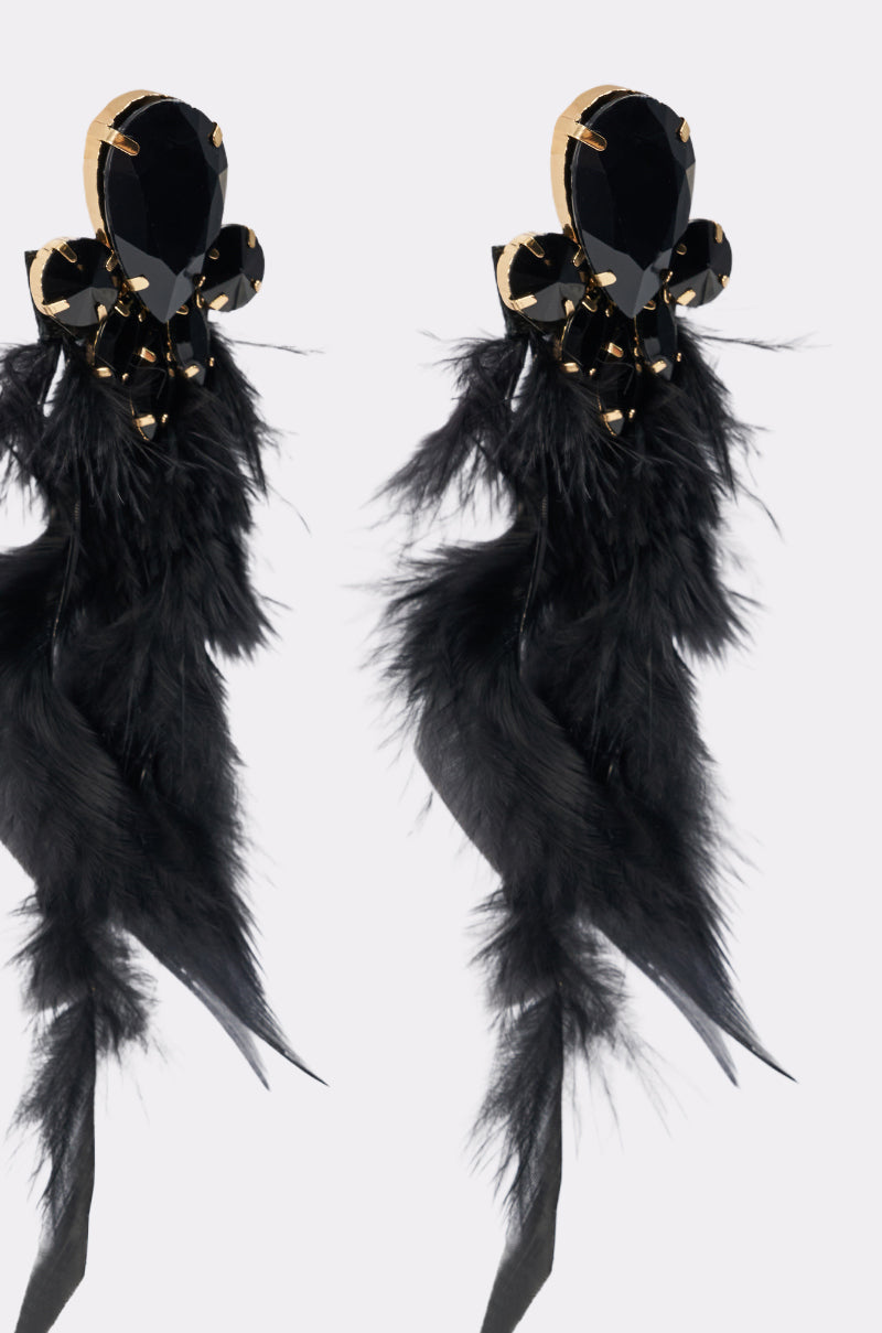 The SHOW ME EARRING features bold black feathers, large faceted black gem tops, gold accents, and small black gems in a floral design—perfect for fans of oversized crystal earrings. 4