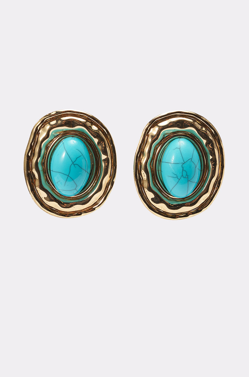 The LONDON EARRING features gold-toned, boho-chic round earrings with textured edges, oversized oval studs, and turquoise center stones with natural veining, showcased against a plain light gray background. 0
