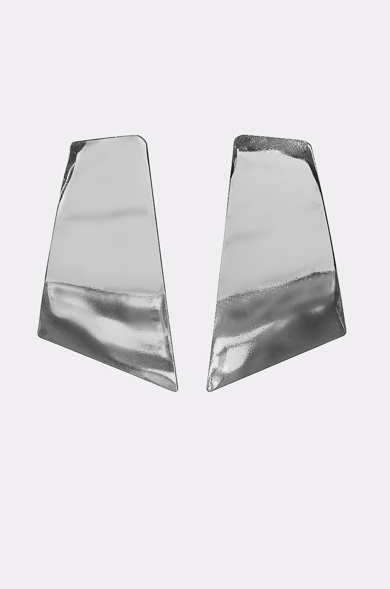 The ON YOUR FEED EARRING features two asymmetrical, silver-tone geometric statement earrings with shiny, angular shapes, displayed against a plain white background. 0