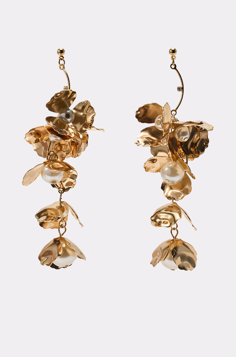 The NOT THE NORM EARRING features gold drop earrings with cascading, sculpted floral shapes and pearl accents. Displayed on a plain light background, these elegant pearl floral earrings are a standout statement piece. 1