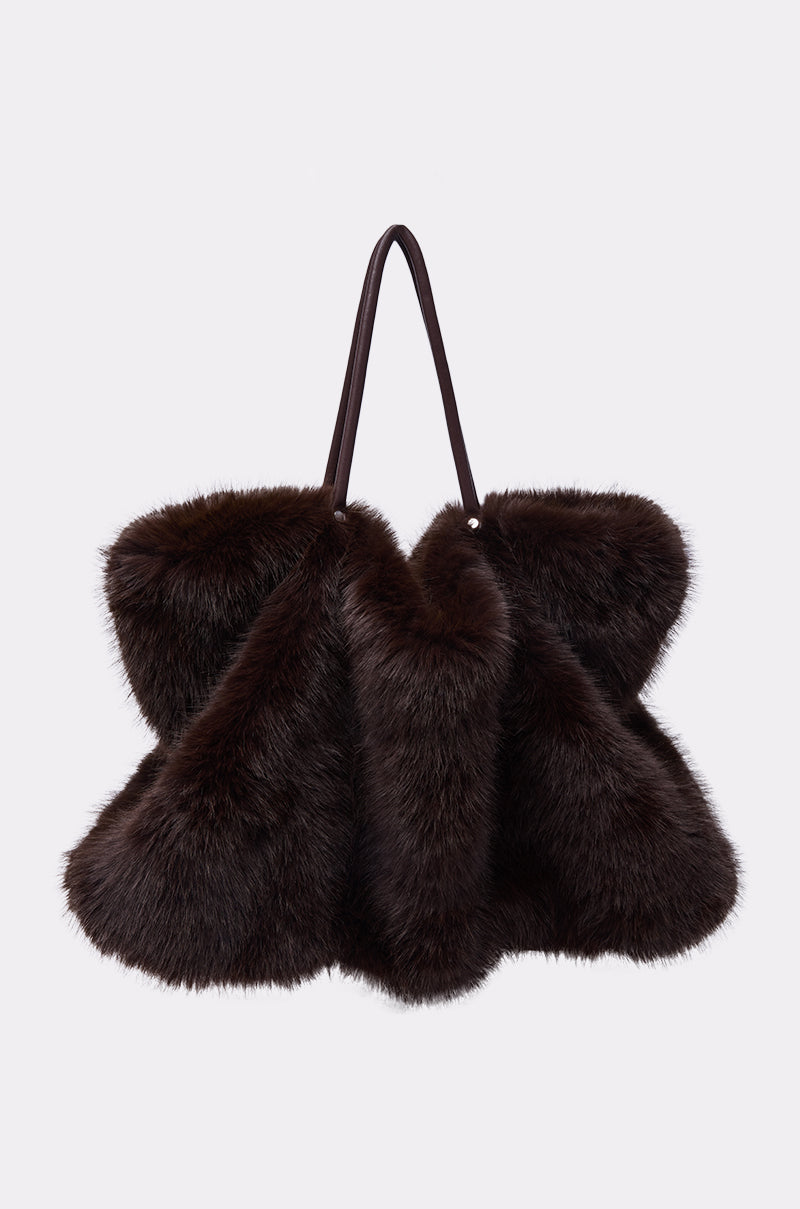 The SO RICH FAUX FUR TOTE, featuring a large, dark brown, fluffy texture and two thin handles, is displayed against a plain light gray background. 1