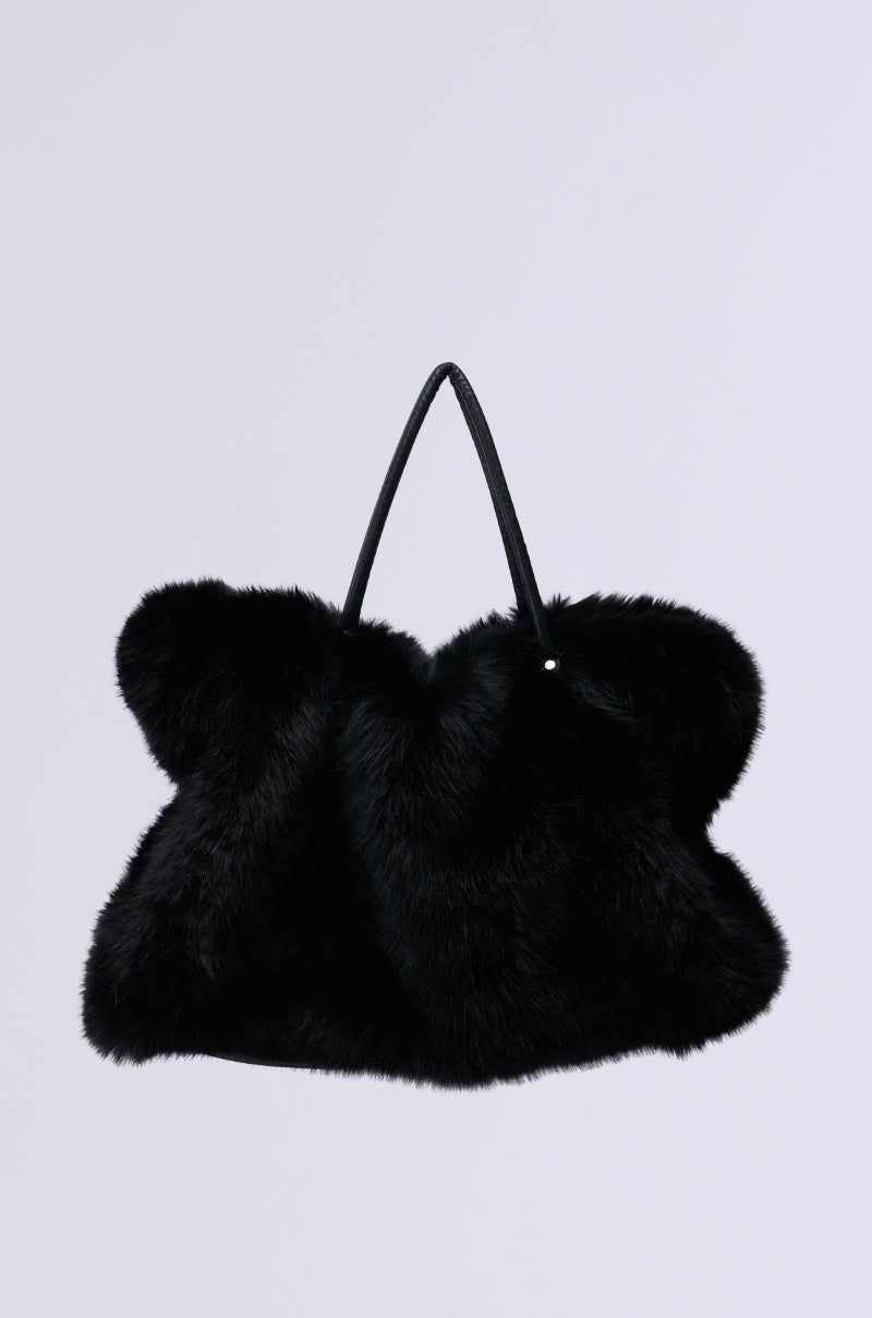 The YETI Large Faux Fur Tote in Black is a plush, oversized handbag with a fur-like texture and two slim black handles, ideal for adding a cozy touch to your winter wardrobe. It is set against a plain light gray background. 4
