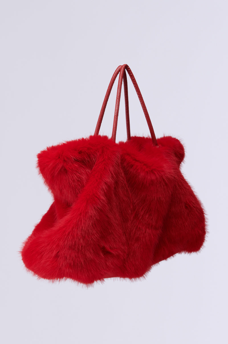 Introducing the LOOK AT ME NOW FAUX FUR TOTE, a luxurious red statement piece with twin handles. This oversized tote features a fluffy and spacious design against a plain white background, perfect for those who love to make an impression. 2
