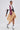 A woman poses confidently in the GET WITH IT BUTTON DOWN BODYSUIT styled with a white cropped top, oversized red and black striped ties, a tan asymmetrical skirt, striped socks, and black heels with gold accents.