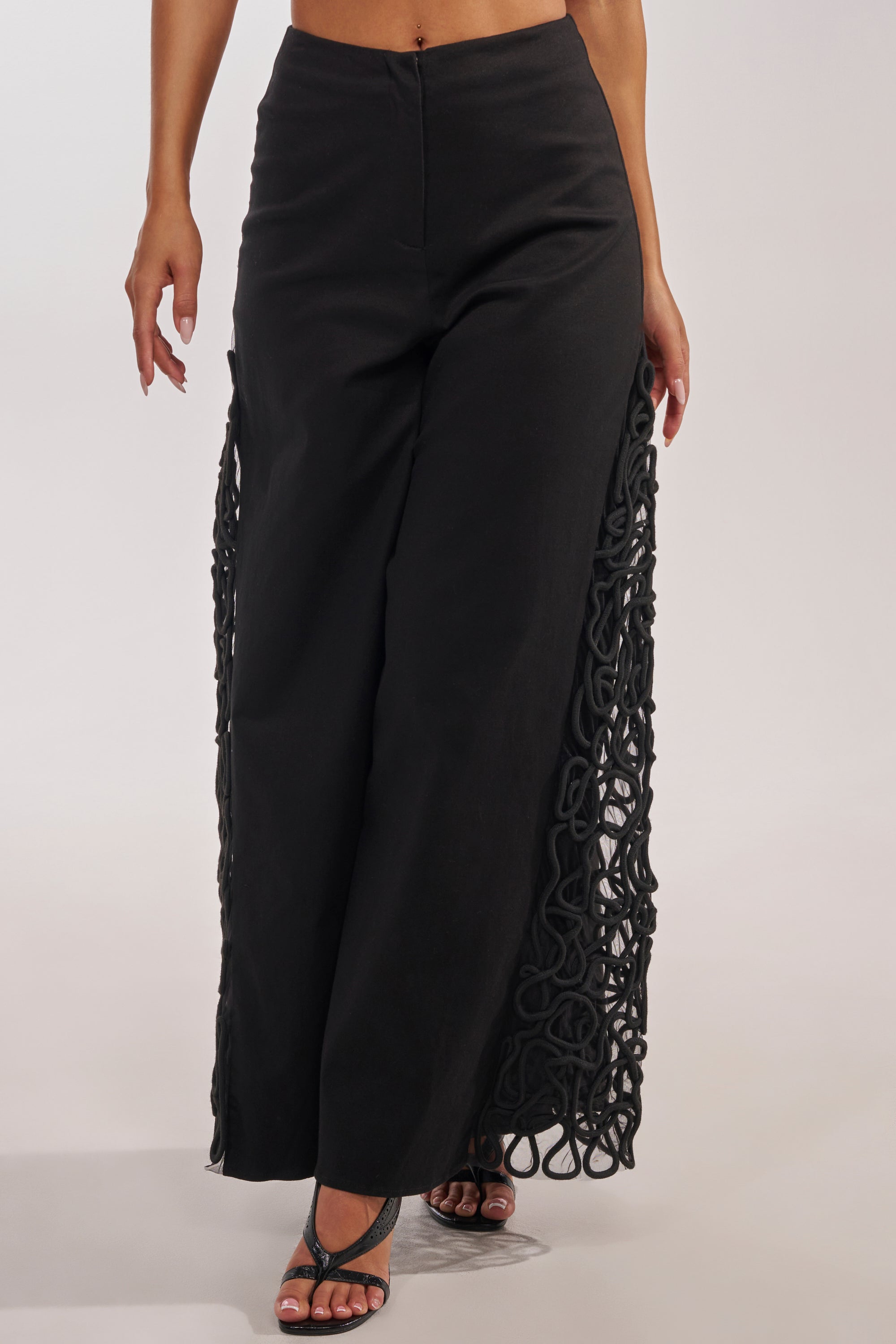 Wearing the ITS GIVING ROPE DETAIL TROUSER, featuring high-waisted wide-leg style and rope detailing along the side seams, paired with black strappy heels—perfect for a formal event against a plain, light background. 3