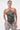 A woman wears the LETS GET FUNKY BEADED TOP, a black halter neckline style adorned with silver studs, paired with gray snakeskin-patterned pants and large hoop earrings, posing against a plain white background.