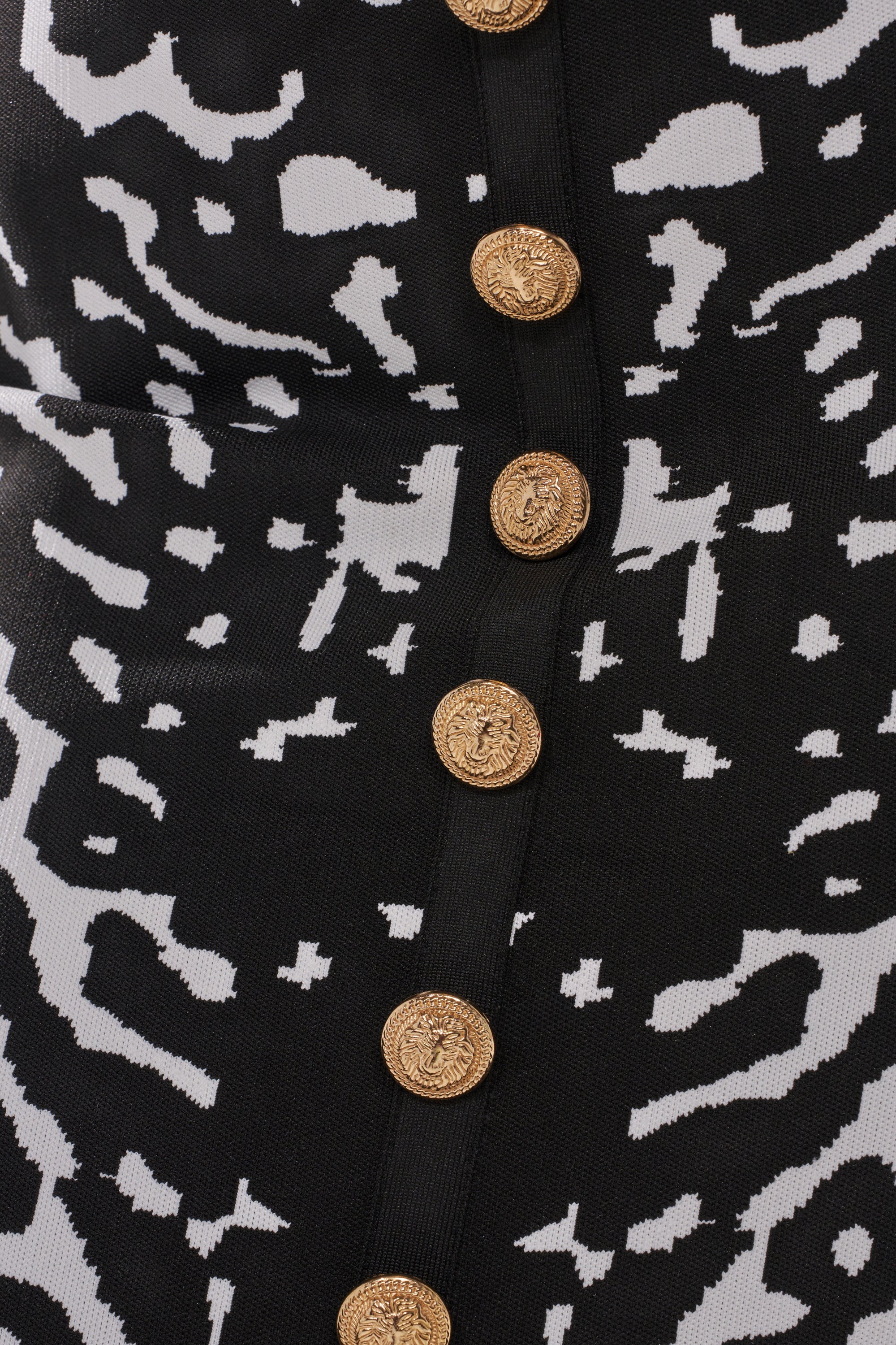 Close-up of the BEST DRESSED MAXI SKIRT, featuring abstract black and white patterns and a vertical row of ornate gold buttons at the center.