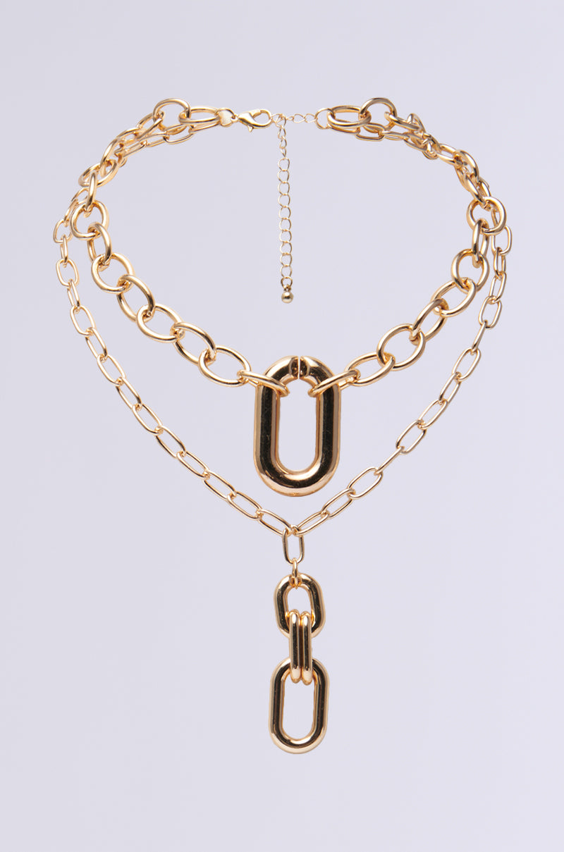 The LUXE LIFE LAYERED NECKLACE is a chic gold piece with three Cuban chain layers of large and small links. It features two standout oval links with drop details, a carabiner pendant, and an adjustable clasp for the perfect fit.