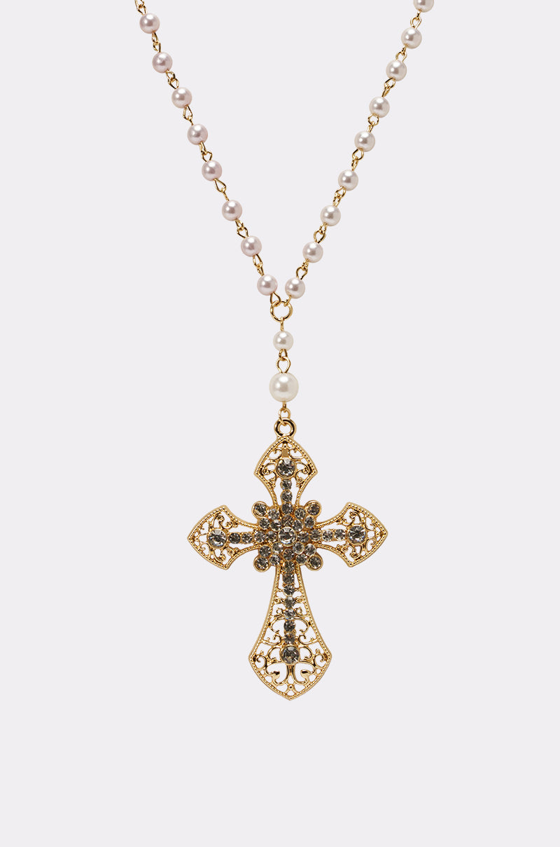 The PRAYERS UP NECKLACE features a gold ornate cross pendant with intricate detailing on a pearl chain, resembling a rosary, displayed against a plain white background. 3