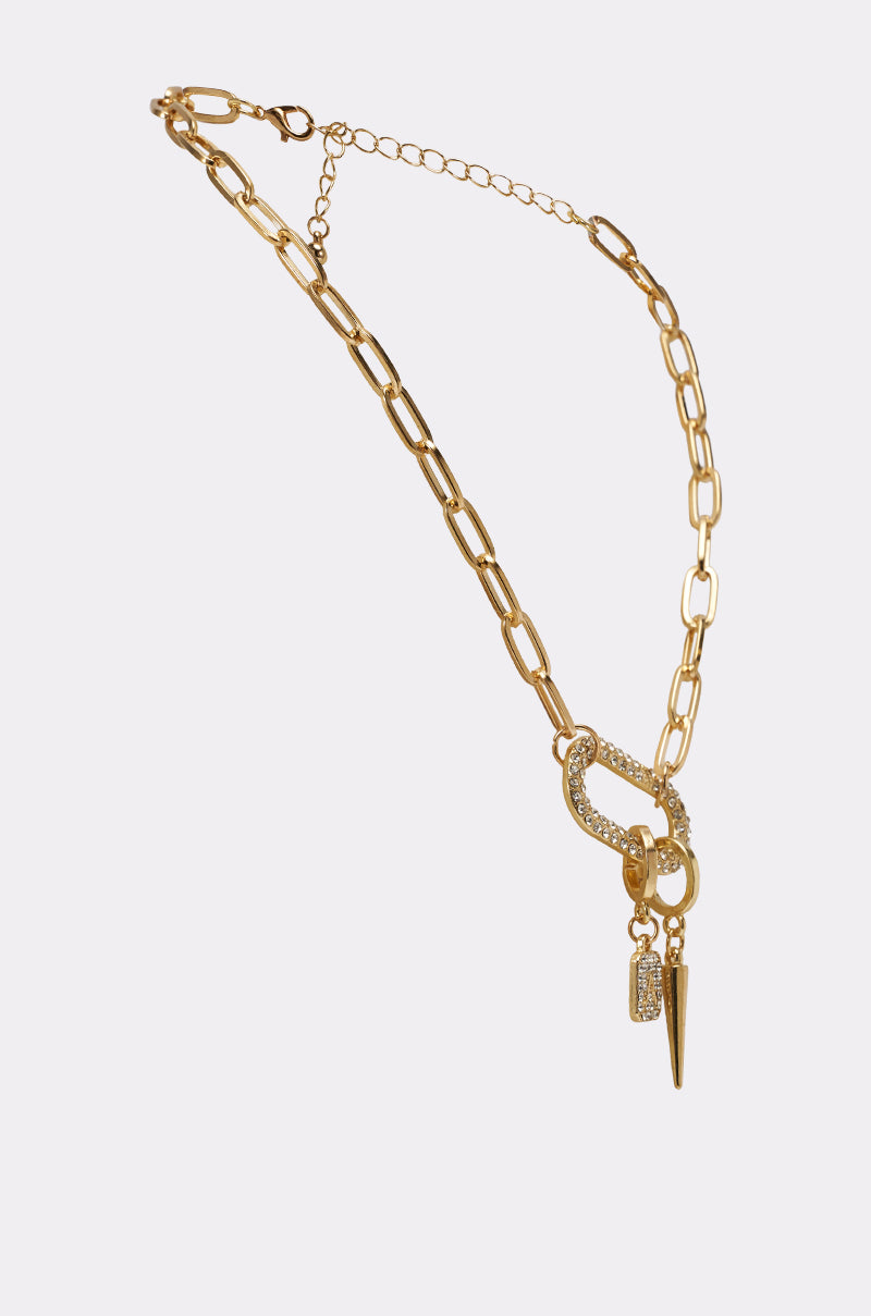 The DESIGNER NECKLACE features a gold paperclip chain with large rectangular links, a sparkly clasp, and two dangling charms—a rhinestone pendant and a spike—shown on a light background. 2