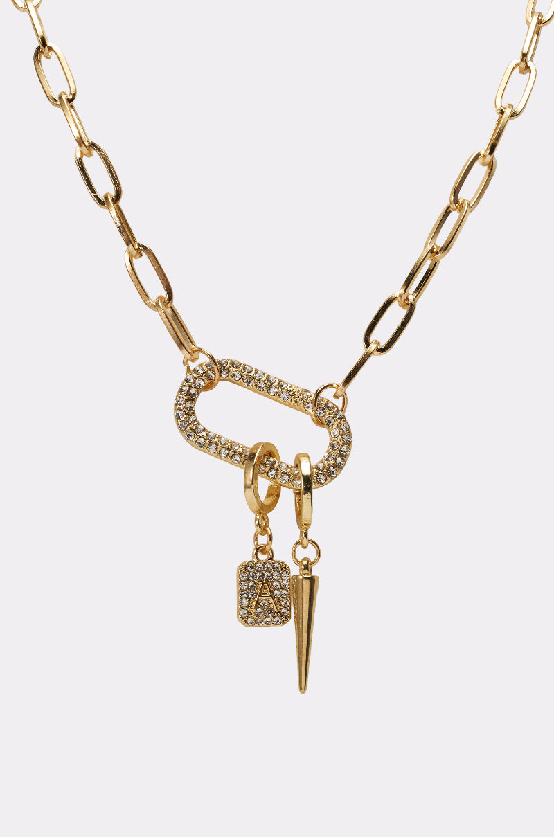 The DESIGNER NECKLACE features a gold paperclip chain with a large oval rhinestone pendant, plus two dangling charms: a square rhinestone "A" and a pointed gold spike. 3