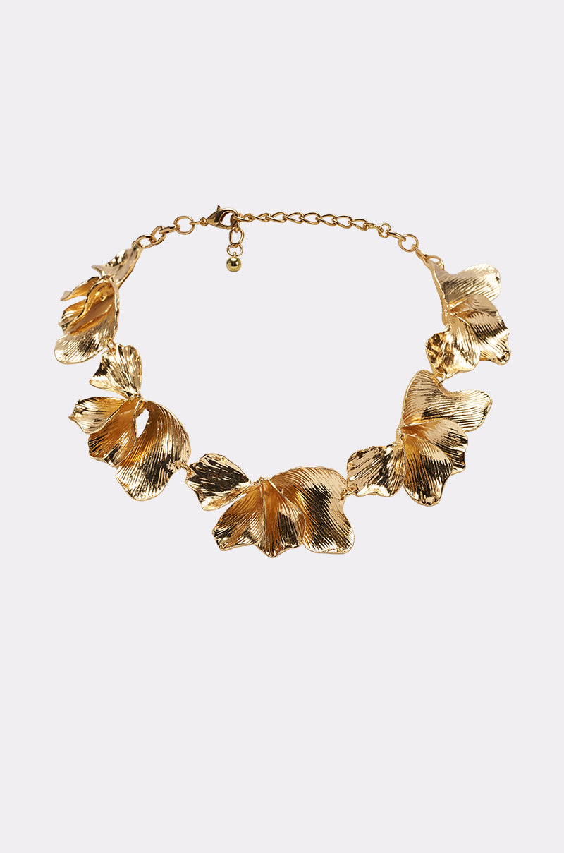 The ON A BEACH NECKLACE is a gold-tone statement piece with five large, textured leaf-shaped pendants featuring intricate detailing, all linked together and finished with an adjustable chain and clasp. 0