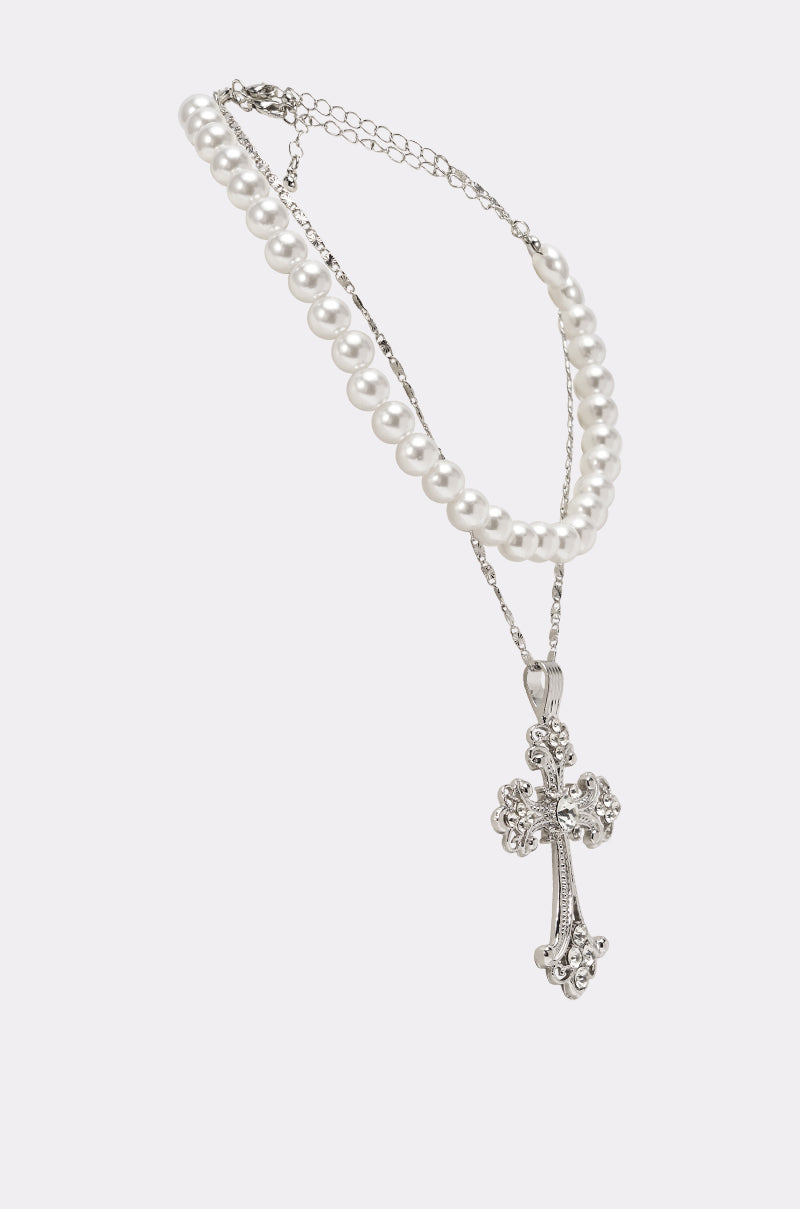 The REGENCY NECKLACE set features a faux pearl choker and a silver chain with an ornate cross pendant, all elegantly displayed on a white background. 2