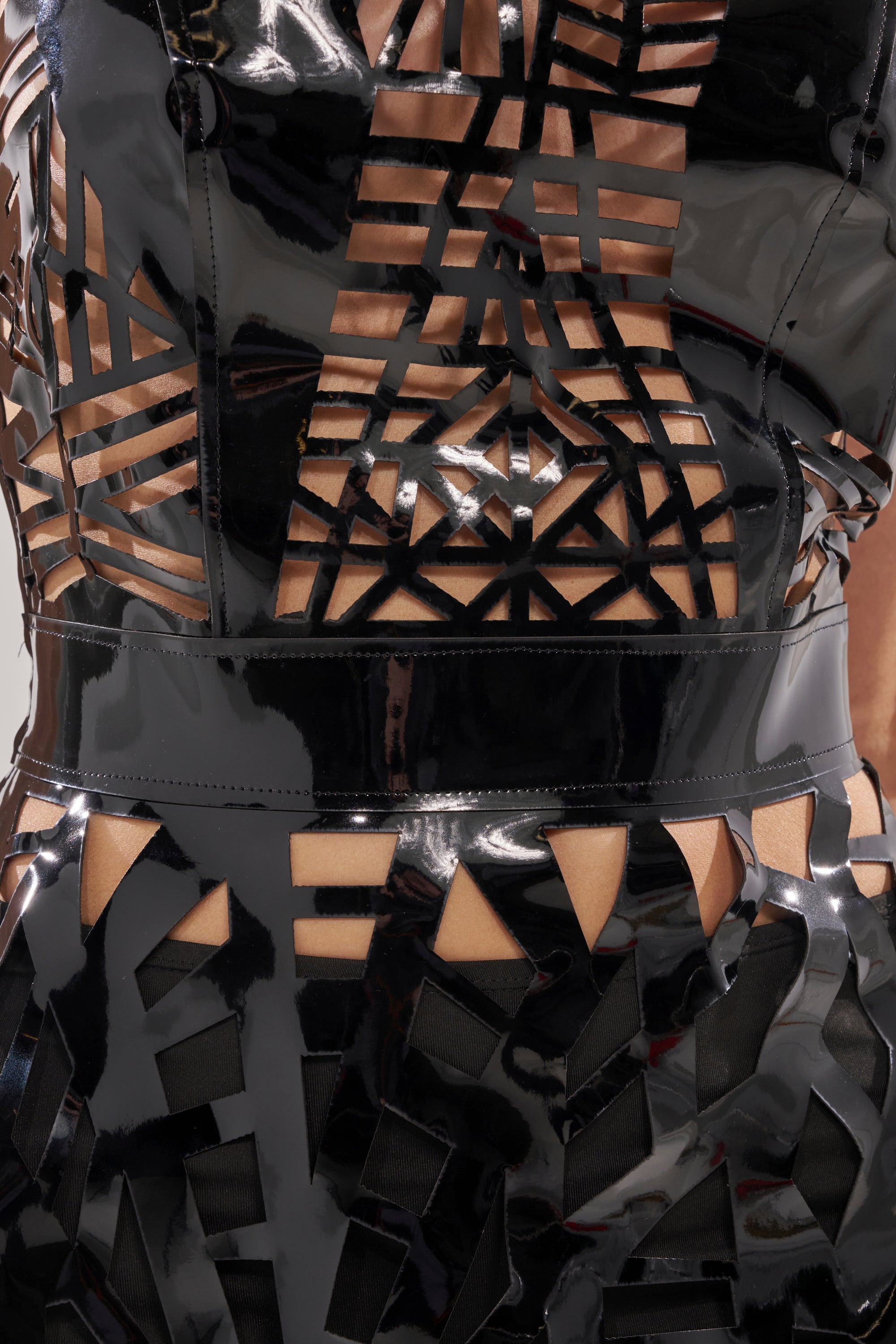 Close-up of the PARTY IN THE BACK CUT OUT MINI DRESS—this glossy, strapless mini features bold geometric cut-outs in triangles and rectangles, revealing skin for a daring statement look.