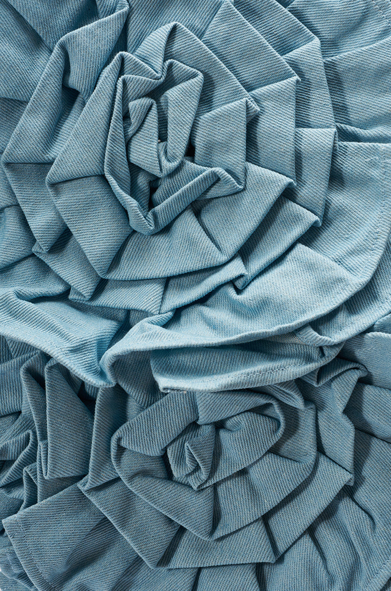 Close-up of the SO FINE DENIM BROOCH, featuring blue denim fabric artfully folded and layered into an avant-garde flower design, highlighting detailed texture and exceptional craftsmanship.