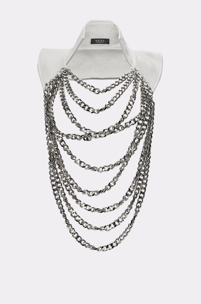 The HEAVY METAL NECKLACE features multiple layered silver chains draped across the front of a white collared shirt, creating a bold, statement necklace-inspired accessory. 0