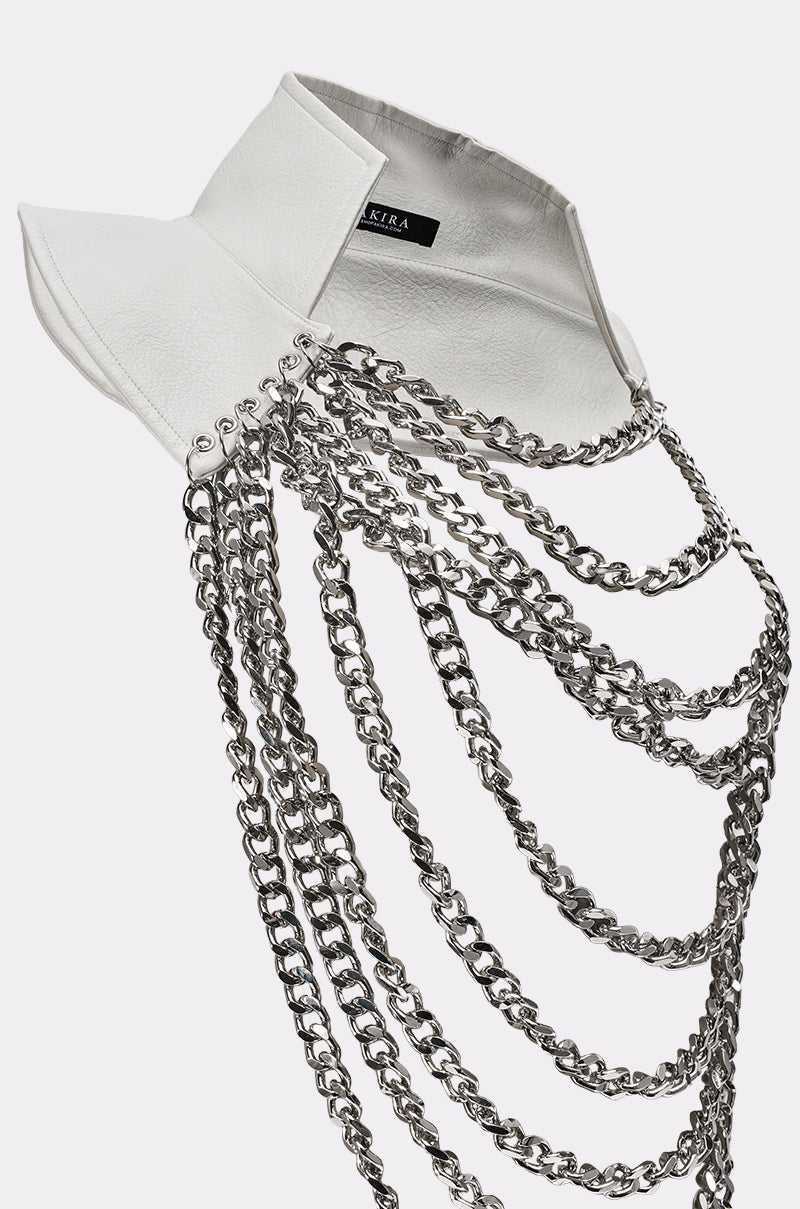 The HEAVY METAL NECKLACE is a white faux leather collar with pointed tips, adorned with multiple silver chains draping across for an edgy, decorative look. 5