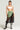 Confidently striking a pose in a white crop top and black lace pants, the model exudes sporty chic. The look is elevated with the SPORTY CHIC STRETCH BELT, distinguished by neon green loops over the pants, and is completed with lace-up heeled boots. Braided hair and statement jewelry lend an extra touch of flair to their style.