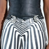 Someone is wearing vertically striped black and white pants with a BUCKLE UP PU BELT, a wide Western-inspired black belt featuring two silver buckles cinching at the waist. Their top is partially visible and white against a plain background.