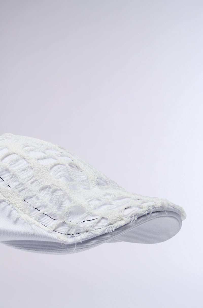 A close-up of a white shoe shows a textured, woven upper with a smooth sole and intricate mesh-like design. It evokes a modern, airy vibe against a plain light gray backdrop, similar to the subtle elegance of the SPREAD THE NEWS TEXTURED CAP's timeless style. 4