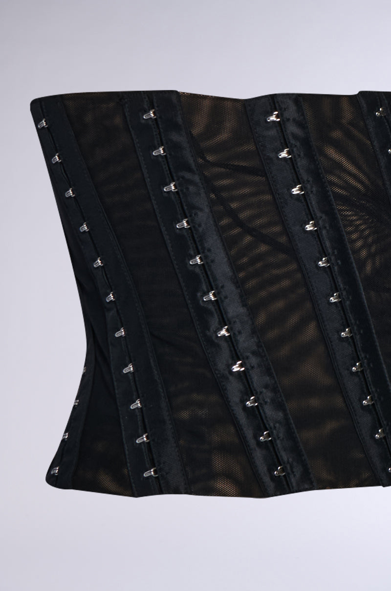 The CINCH ME UP STRETCH BELT is a black corset-style garment with multiple hook-and-eye closures for waist cinching, complemented by faux leather trim. Made from a combination of stretchy double-lined mesh and solid materials, it provides support and breathability. 5