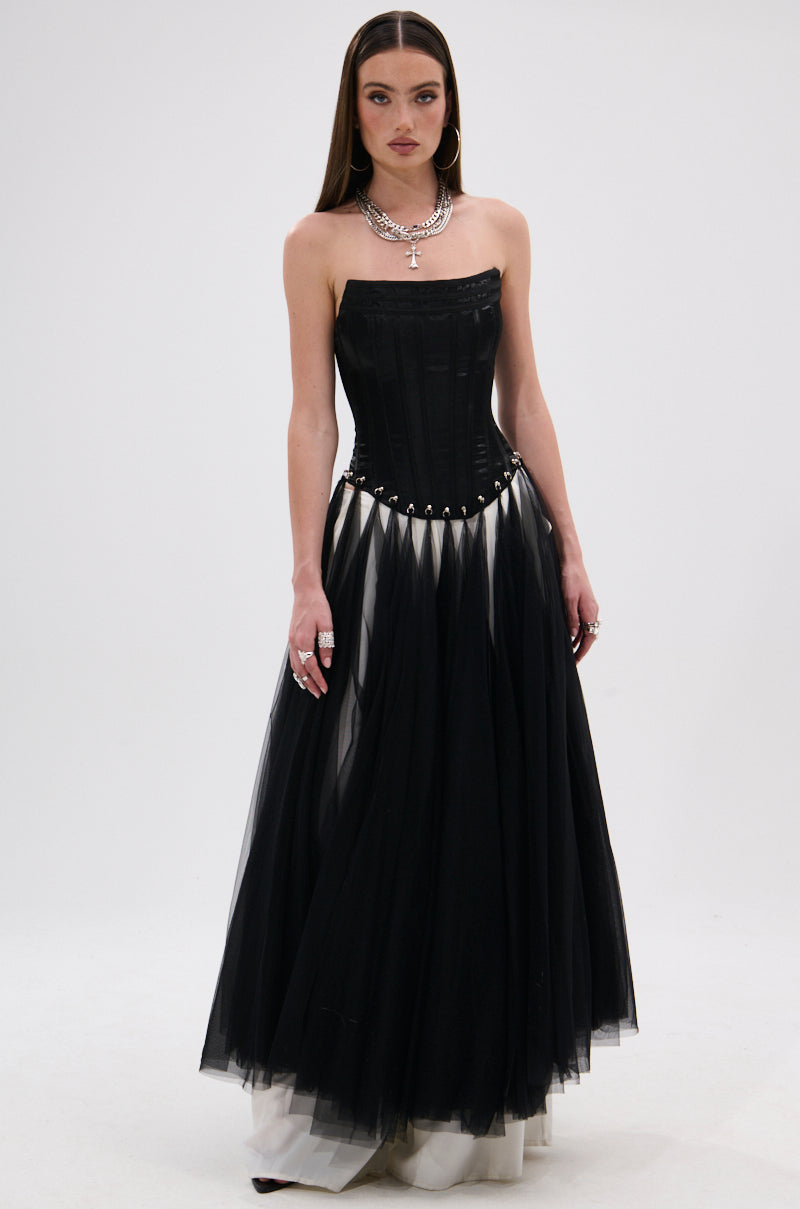 A woman wears the MARRIED TO THE GAME CORSET TOP IN BLACK, styled strapless with a lace-up back, paired with a full tulle skirt, hoop earrings, layered necklaces, and rings against a plain white background.