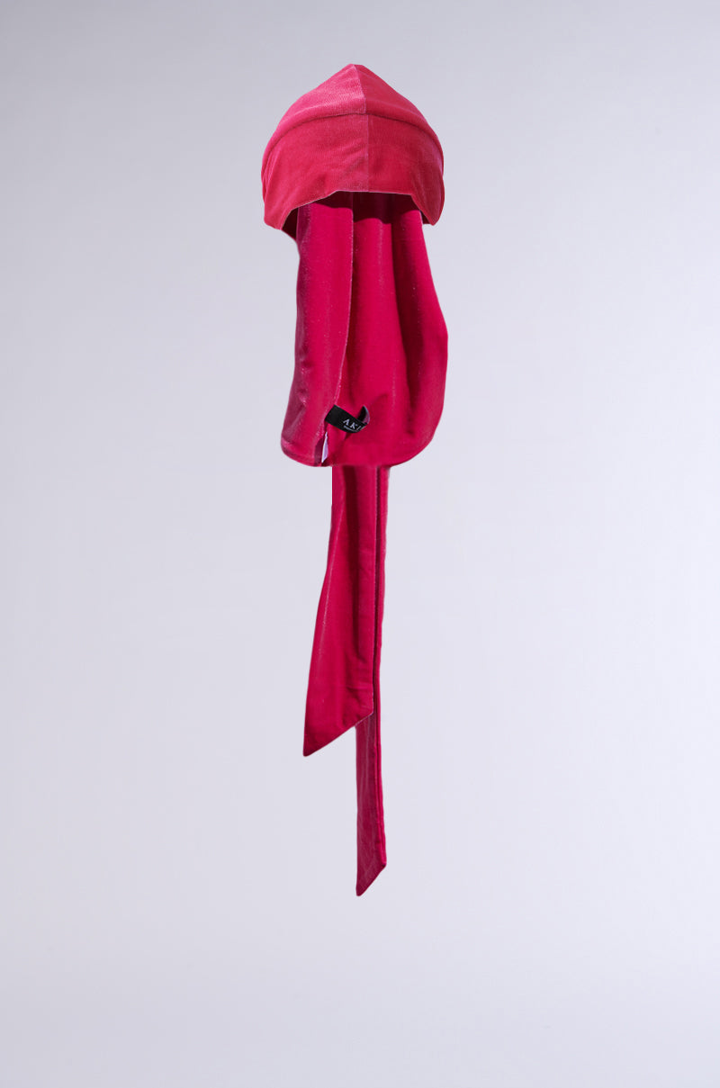 A red RAY VELVET DURAG with long tails and a smooth texture is displayed against a plain light gray background.
