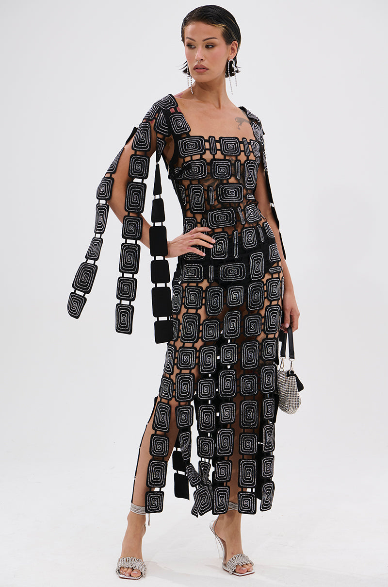 A woman stands confidently in the ONLY ONE OF ME RHINESTONE MIDI DRESS, featuring geometric cutouts and sparkling rhinestone details.