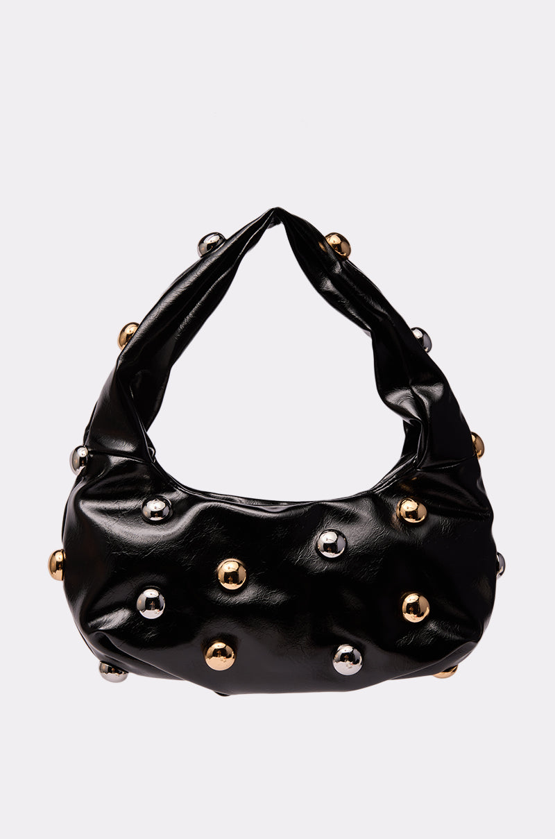 The TOO MOD BALL PURSE is a black, shiny faux leather bag with a short, wide handle, adorned with evenly spaced round gold and silver studs. 1