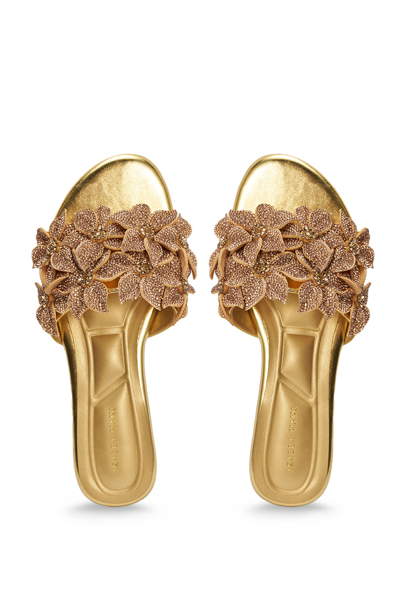 The AZALEA WANG YUNA Gold Flat Sandal is a faux leather slip-on with open toes, cushioned soles, and rhinestone embellishments across the straps for an elegant, embellished look. 3