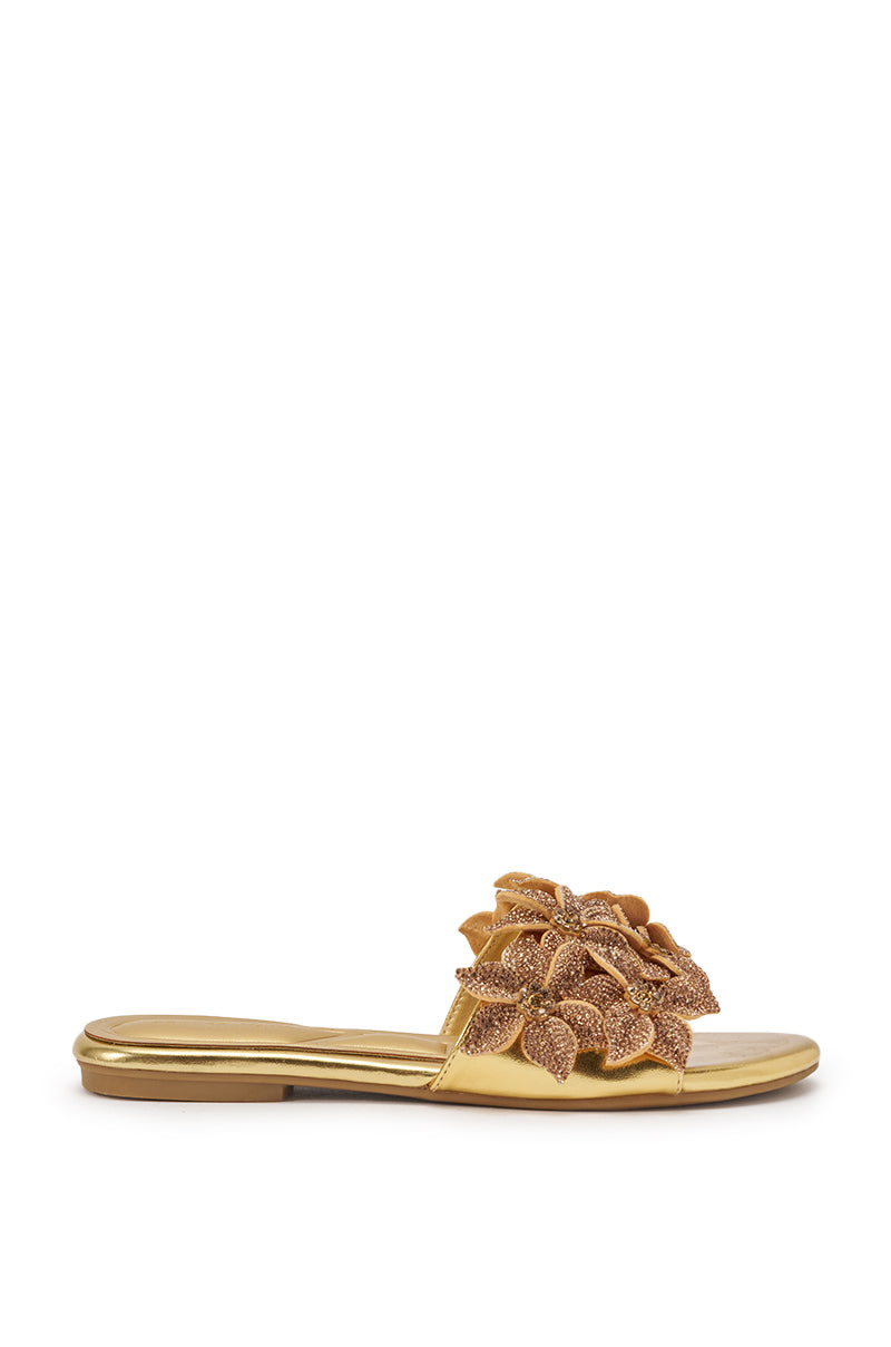 The AZALEA WANG YUNA Gold Flat Slip On Sandal features a gold faux leather design with a large rhinestone-embellished flower on the upper strap, displayed against a plain white background. 4