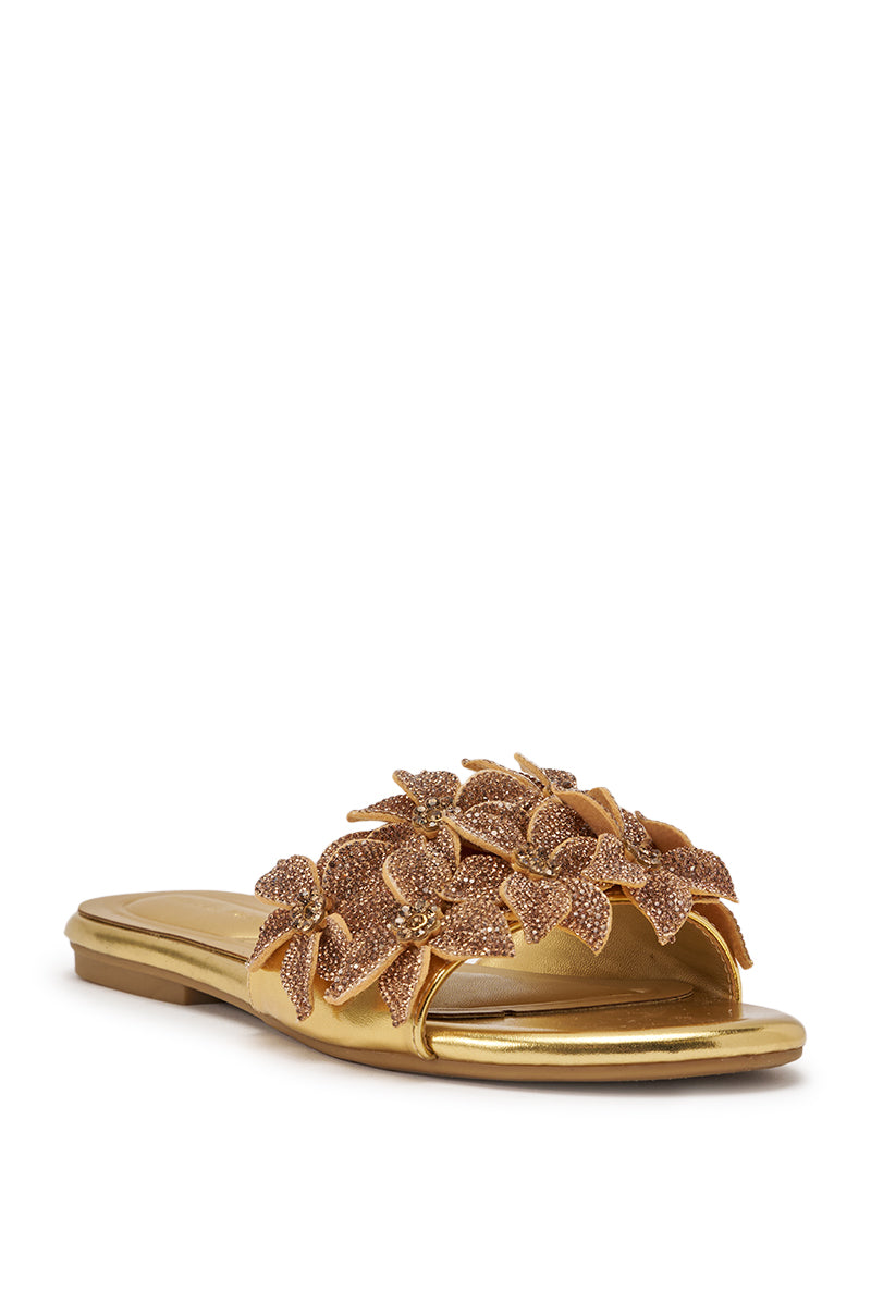 The AZALEA WANG YUNA GOLD FLAT is a gold faux leather slip-on sandal with rhinestone-embellished three-dimensional floral appliqués on the strap, displayed at a slight angle against a white background. 5