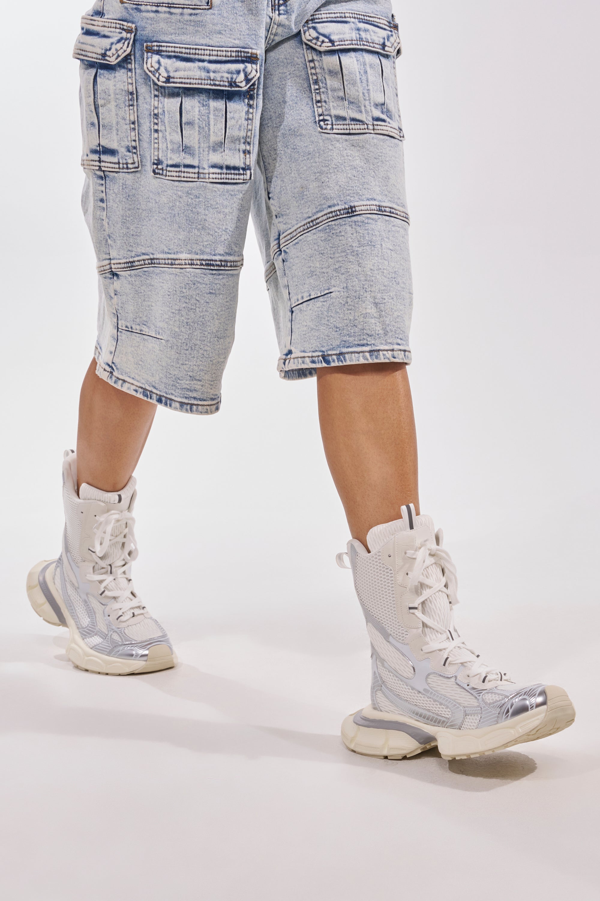 A person stands against a plain white background wearing knee-length light-wash cargo shorts and AZALEA WANG YVONNE WHITE LACE UP SNEAKER. 1