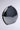 A shiny dark gray, circular sculpture with a metallic silver surface stands against a neutral background, its smooth and reflective finish gleaming with subtle highlights and shadows, reminiscent of the elegant sophistication embodied by the MIDNIGHT DREAMIN METAL CLUTCH.