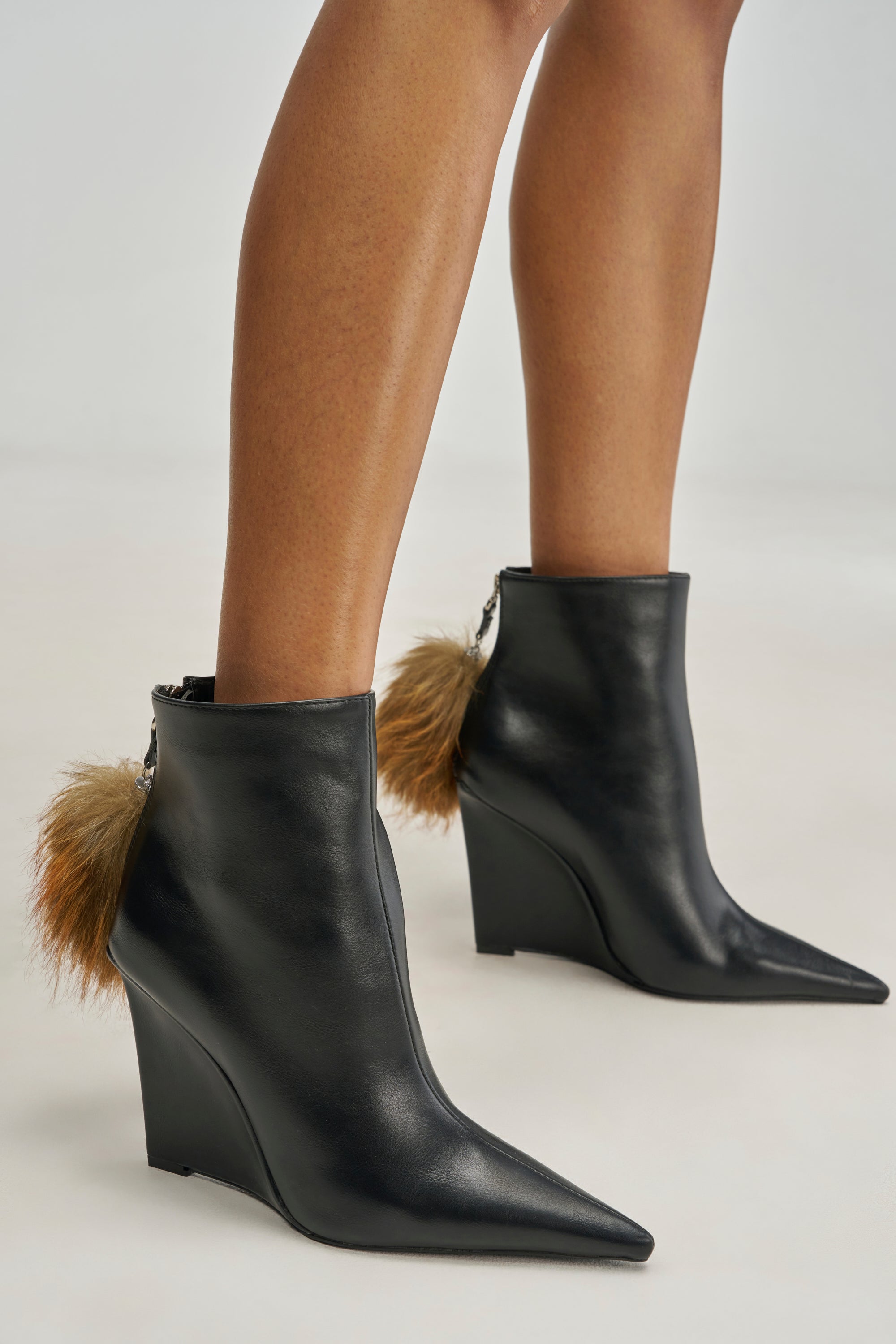 AZALEA WANG ZDENKA BLACK WEDGE BOOTIE WITH FUR POM POM: black faux leather pointed-toe wedge booties with a fur pom-pom attached to the back zipper.