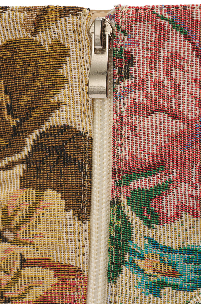 Close-up of a metal zipper sewn between two sections of floral-patterned fabric, similar to the detailed textures on the AZALEA WANG ZILPAH FLORAL BROCADE BOOTIE—one side brown and yellow, the other pink and green. 6
