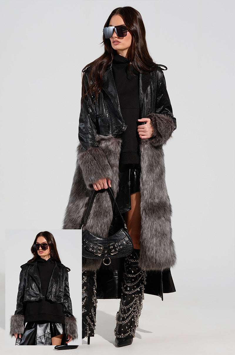 A person dressed in the 2 IN 1 MOTO FUR TRENCH, which features black faux fur with gray trim, paired with a black skirt and knee-high patterned boots. They hold a Croc-embossed vegan leather handbag and sport large sunglasses. A smaller inset image provides a different perspective of the same ensemble.
