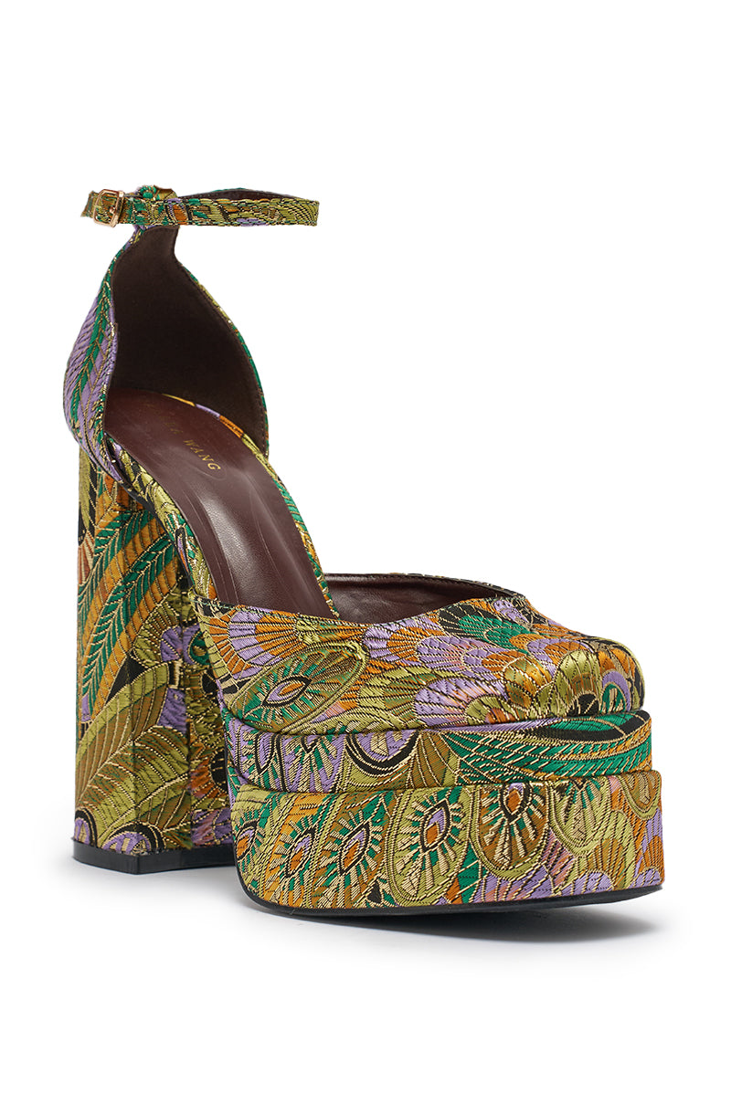 The AZALEA WANG ZIPPHORA GREEN MULTI BROCADE PLATFORM PUMP features ankle straps, a vibrant brocade pattern with leaves and peacock feathers in green, gold, and purple, gold metallic accents, and a chunky block high heel. 9