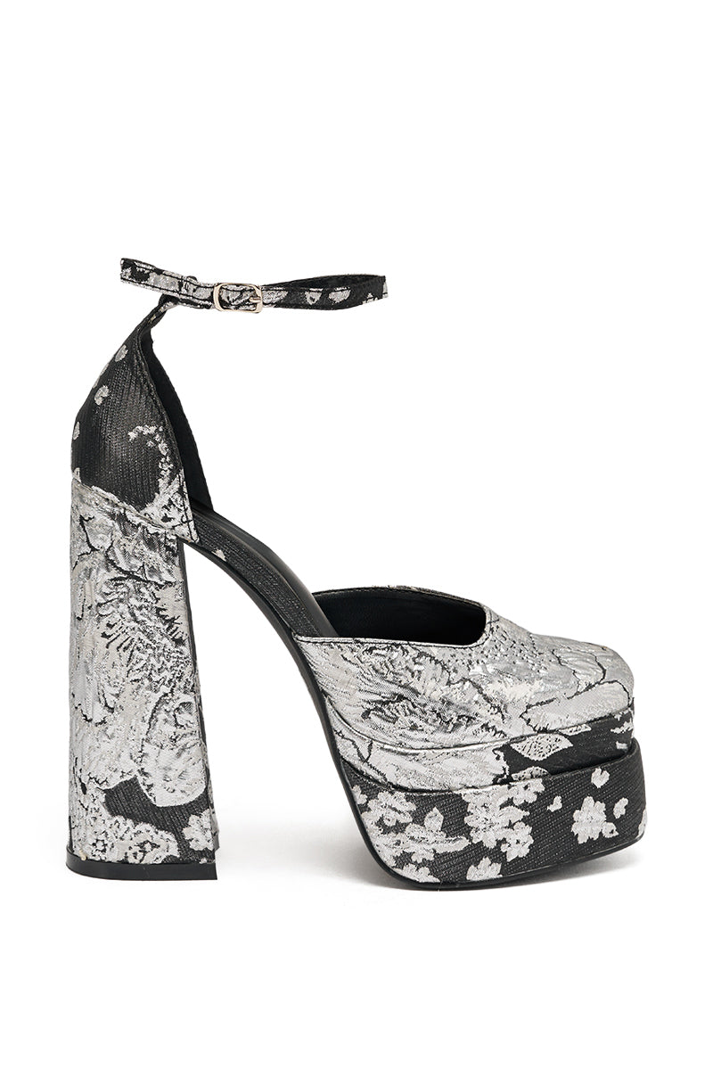 The AZALEA WANG ZIPPORAH BLACK BROCADE PUMP features a chunky high heel, ankle strap, platform sole, and a bold black-and-white floral brocade pattern.