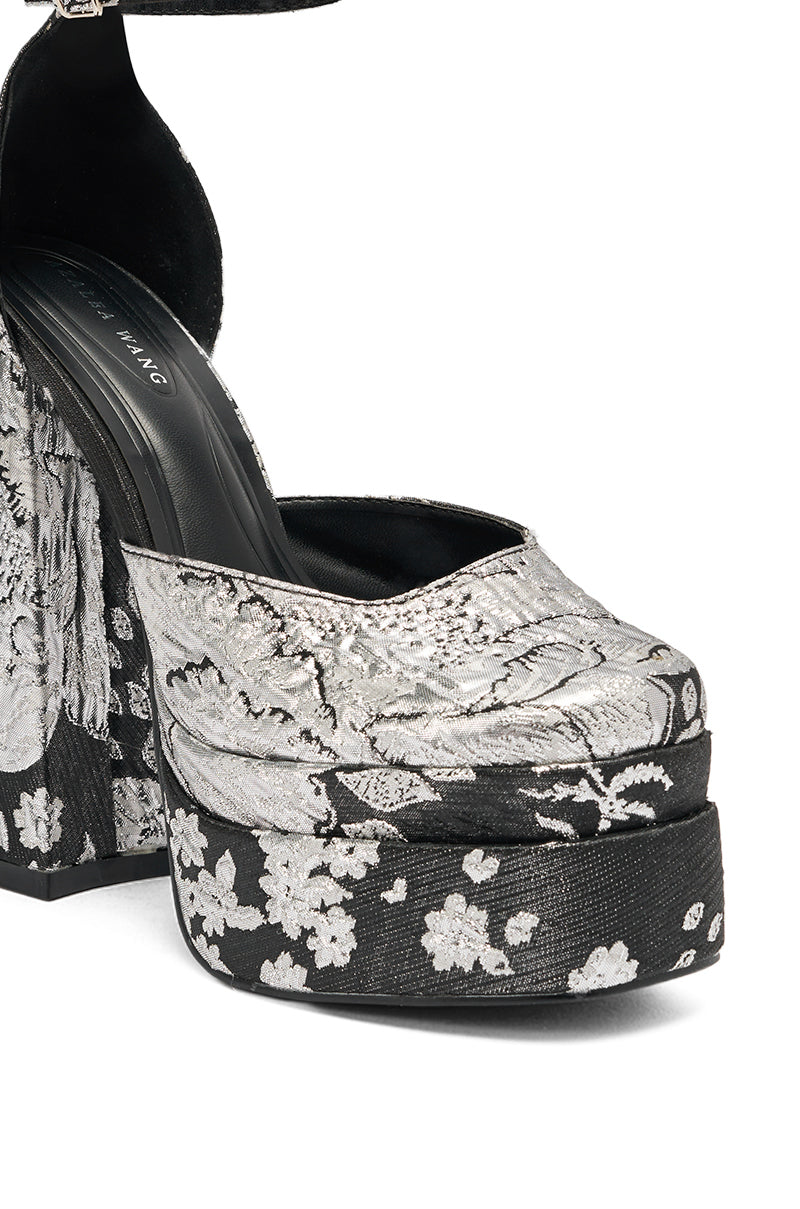 The AZALEA WANG ZIPPORAH BLACK BROCADE PUMP is a black brocade platform heel with silver floral embroidery, a chunky heel, and a chic ankle strap.
