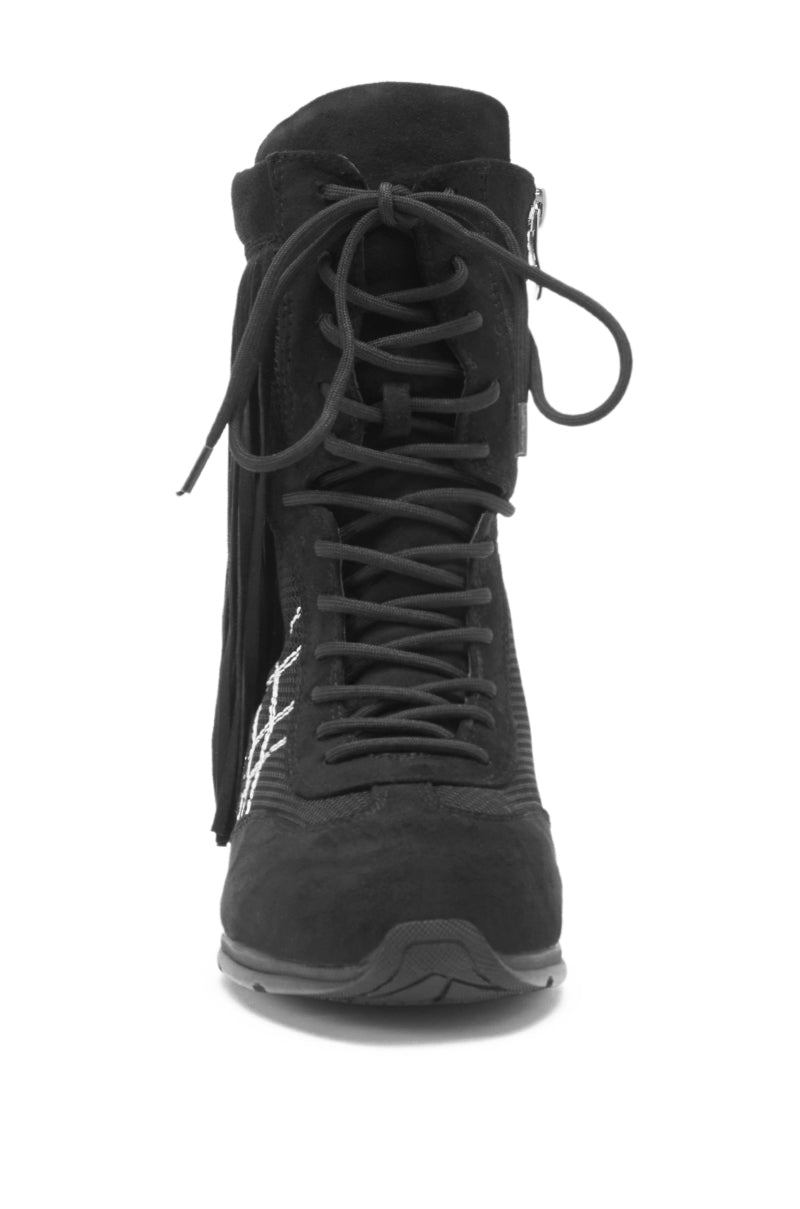 Front view of the AZALEA WANG ZITHER BLACK FLAT FRINGE BOOTIE, showcasing black suede with lace-up front, side zipper, fringe details, and decorative stitching, displayed against a white background.