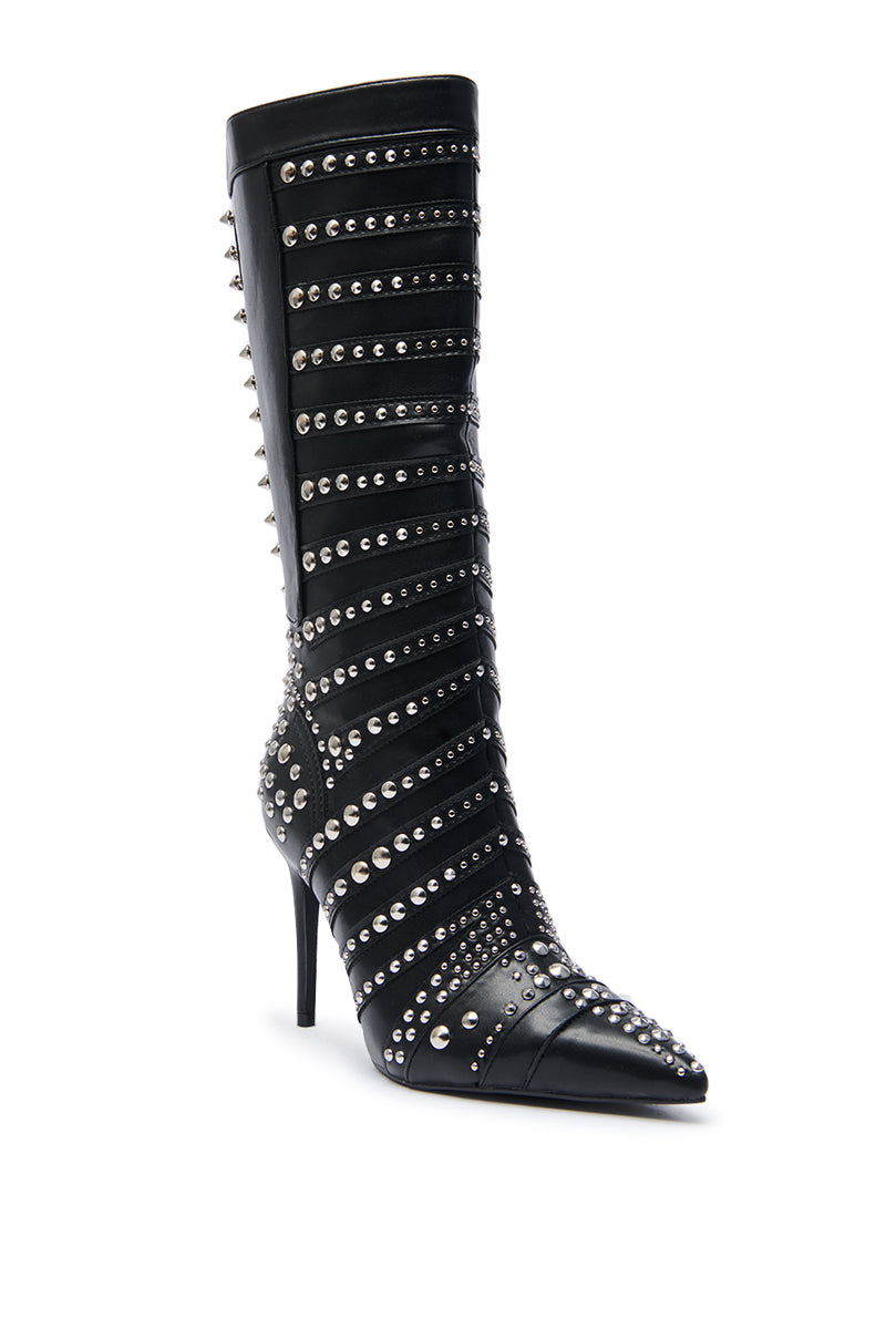 The AZALEA WANG ZOX Black Rhinestone and Studded Black Bootie is a knee-high stiletto with a pointed toe, featuring bold horizontal rows of silver studs and rhinestones for an edgy look.