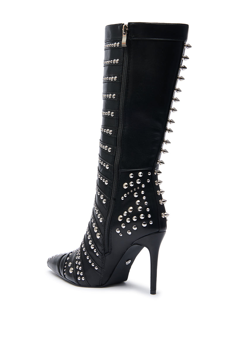 The AZALEA WANG ZOX Black Rhinestone and Studded Black Bootie is a black knee-high boot with silver studs, rhinestones, a side zipper, pointed toe, and tall slender stiletto heel.
